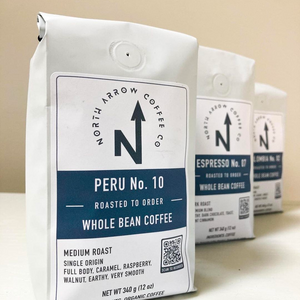 Three retail bags of North Arrow Coffee Company's coffee, labeled Peru No. 10, Espresso No. 07, and Colombia No. 02