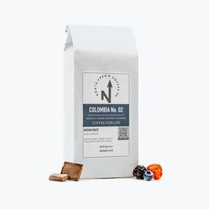 A white bag of Colombia No. 02 coffee with a label showing the brand name, product name, and additional details such as 'Single Origin', 'Organic', and 'EP Certified'.